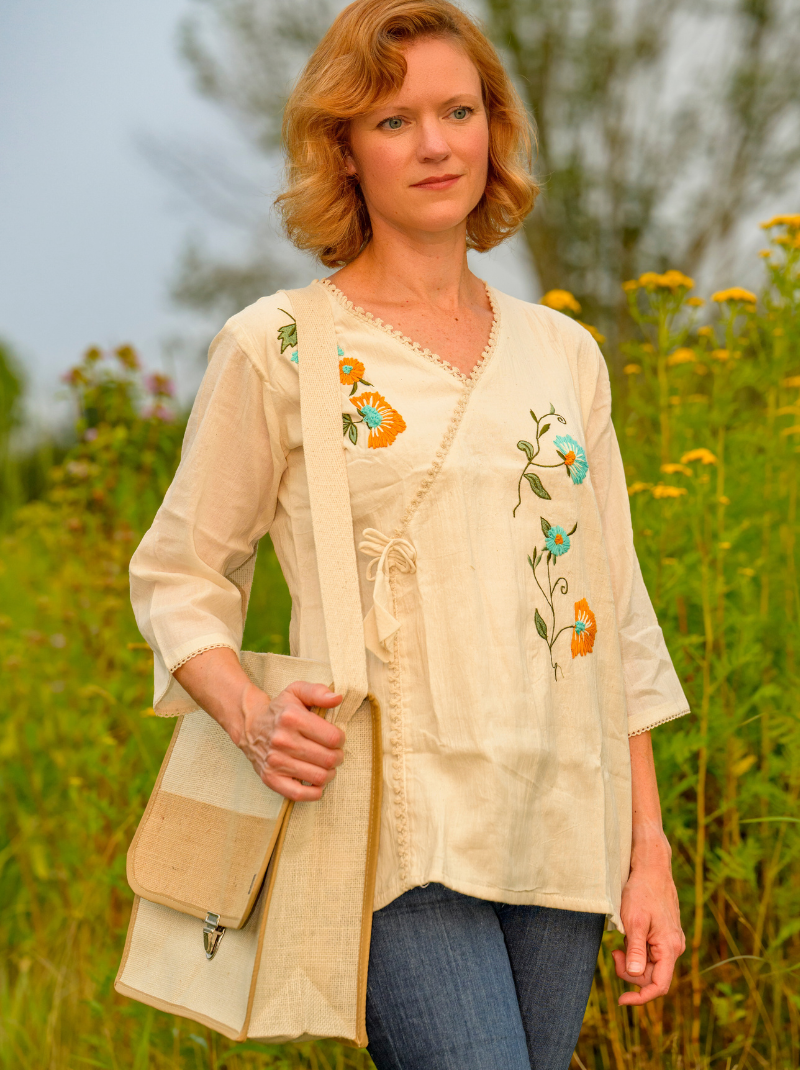 Woman wearing a beige embroidered blouse in a field