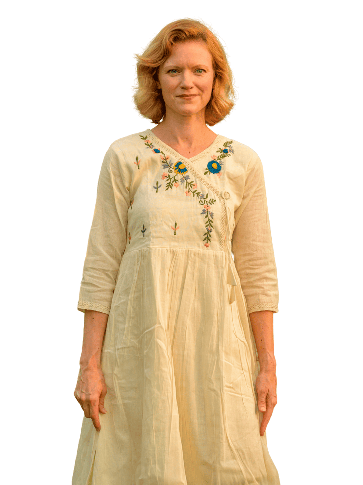 Woman wearing a beige embroidered dress on a white background