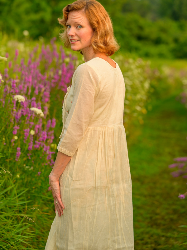 Woman in a white dress standing in a field of purple flowers
