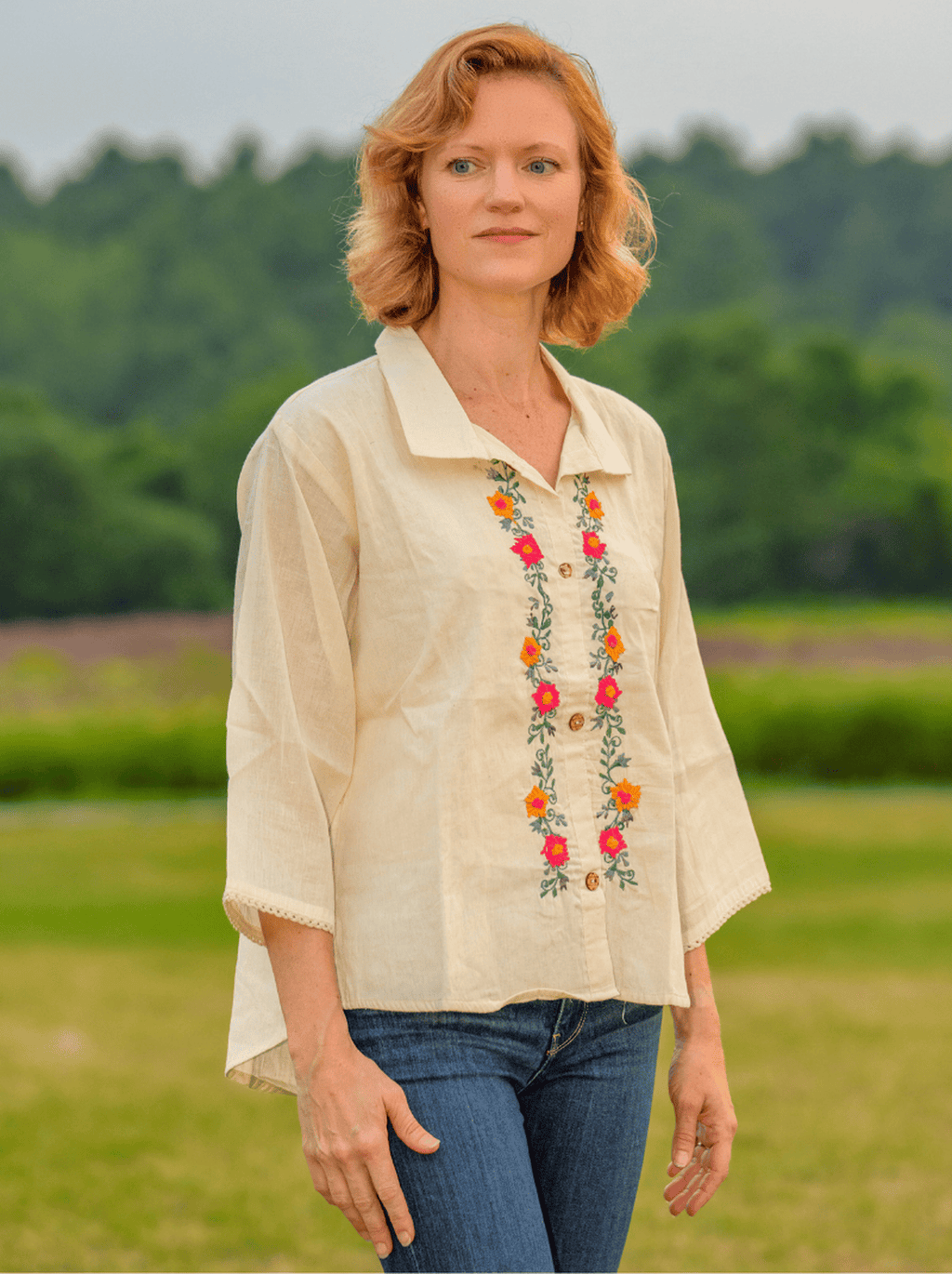 Woman wearing a beige blouse with floral embroidery outdoors