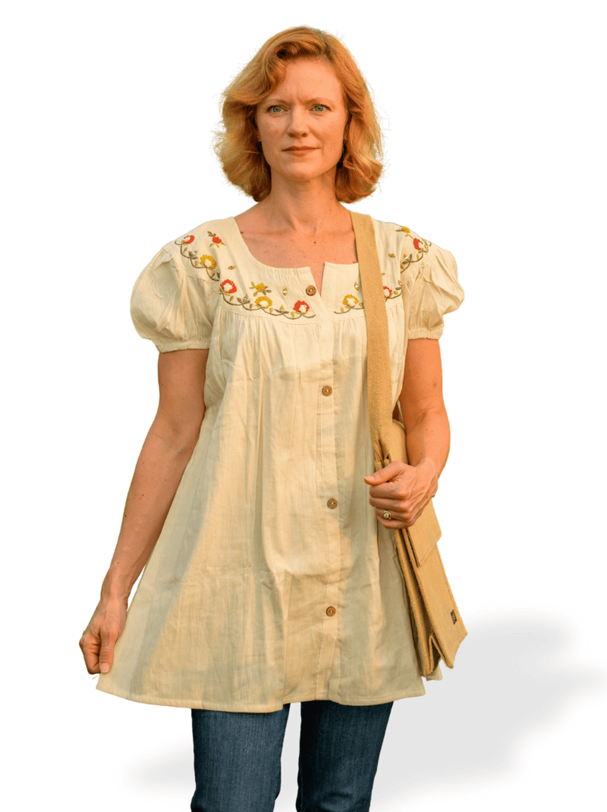 Woman wearing a beige embroidered blouse with a plain background