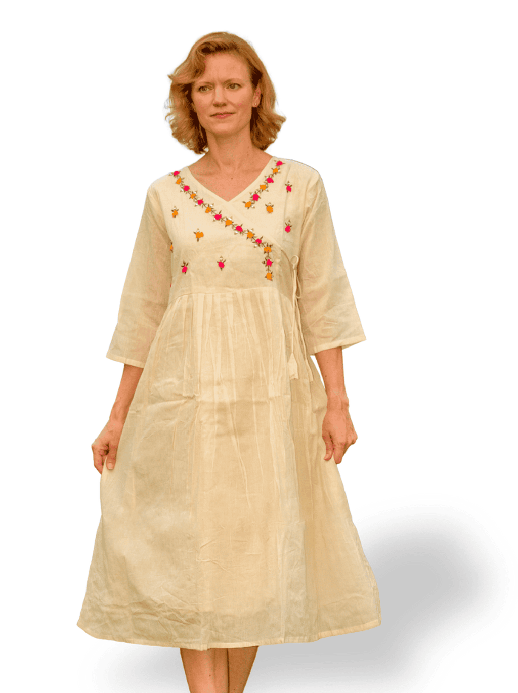 Woman wearing a beige dress with floral embroidery on a white background