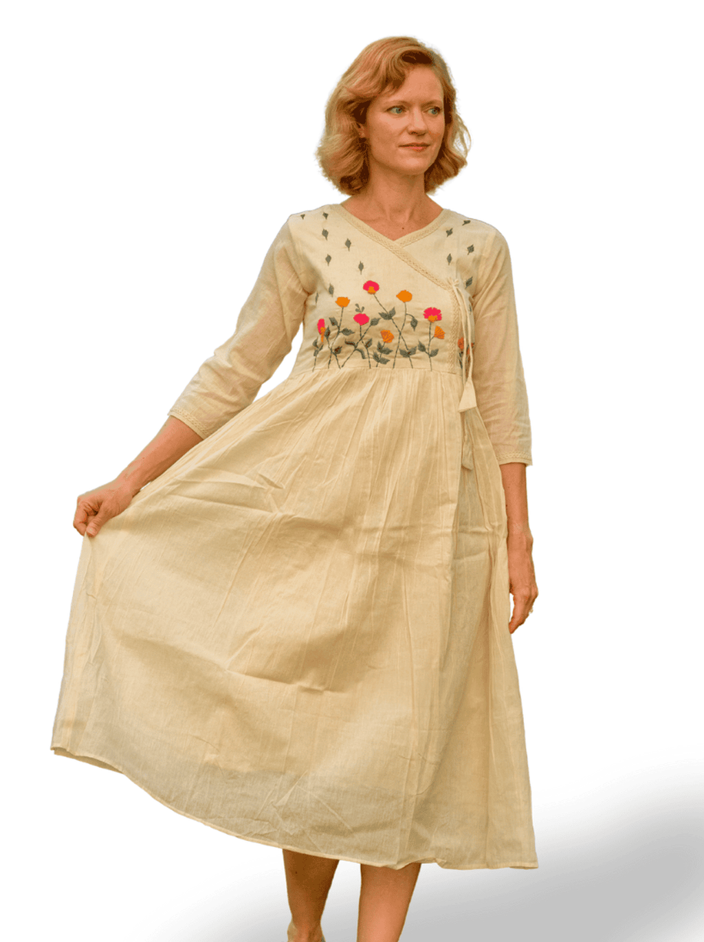 Woman wearing a beige dress with floral embroidery on a white background
