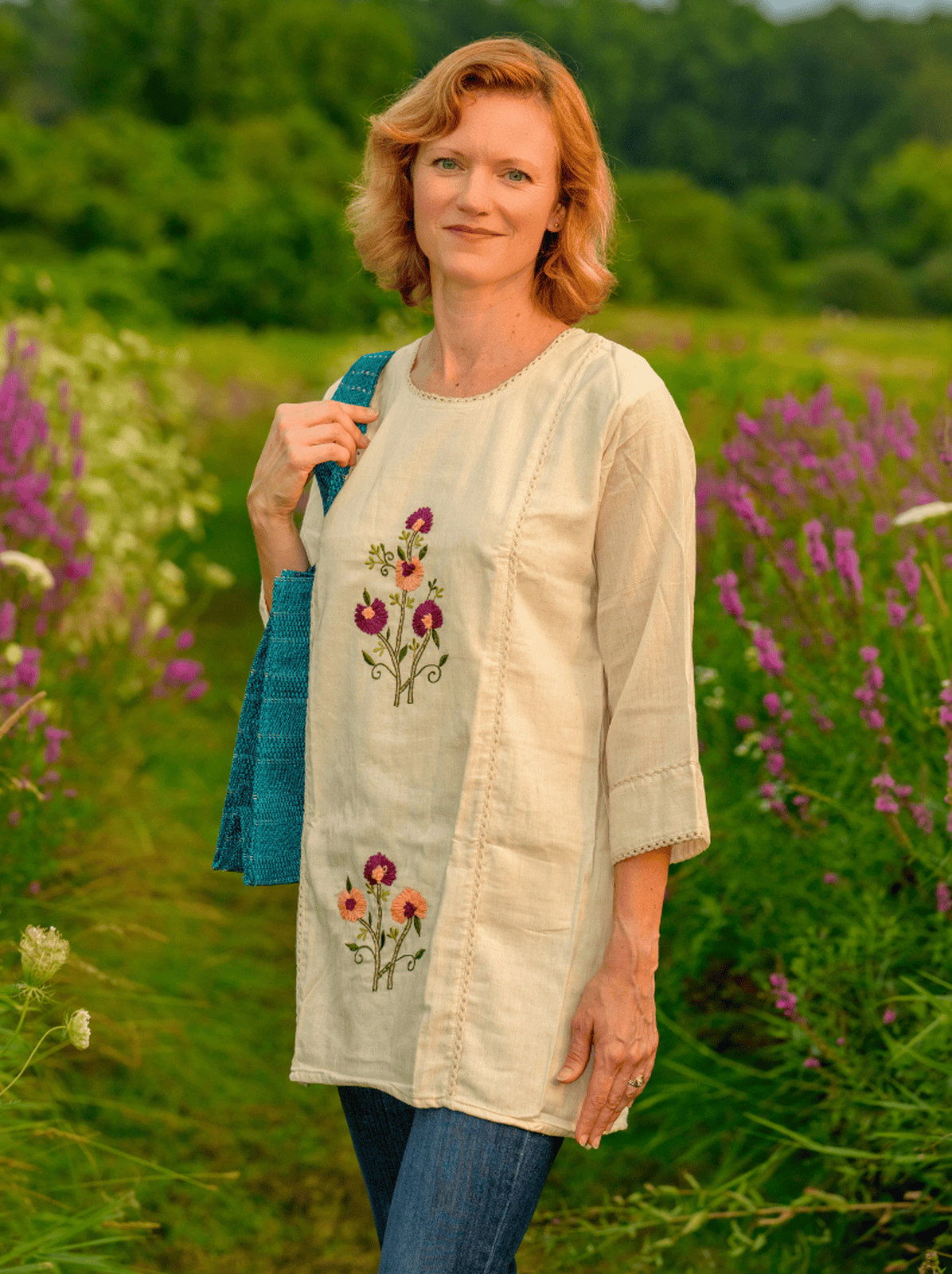 Woman wearing a beige embroidered top in a field of flowers