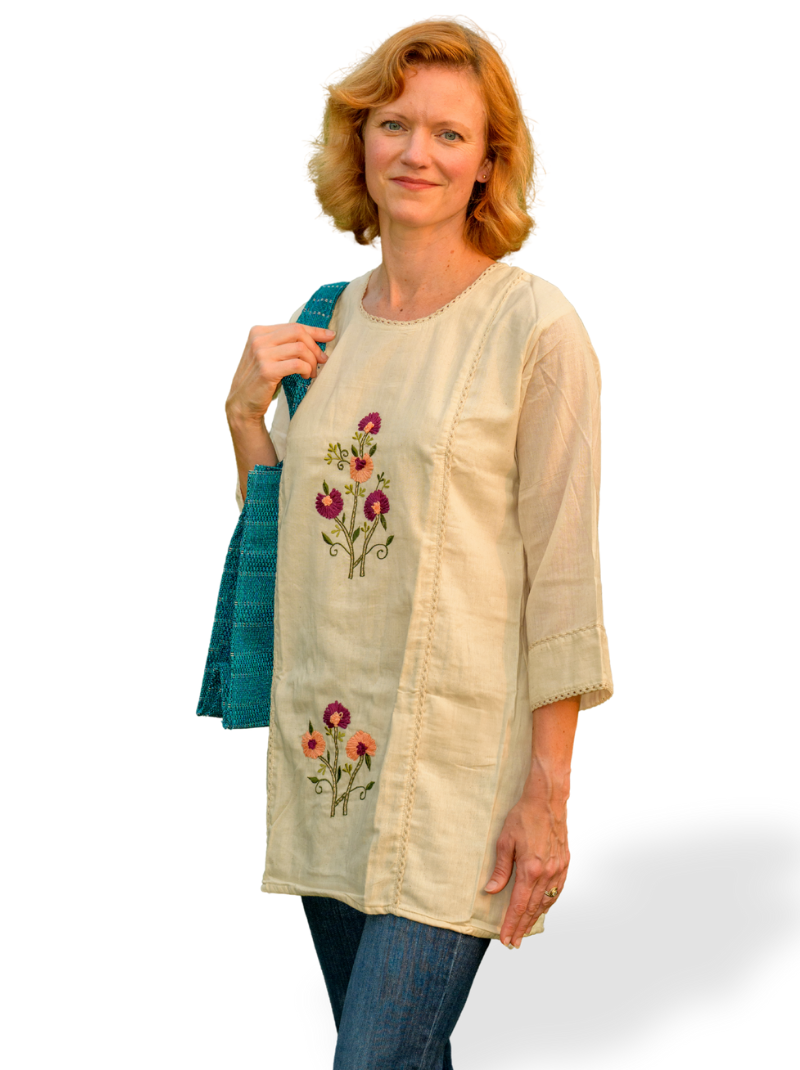 Woman wearing a beige embroidered tunic with a white background